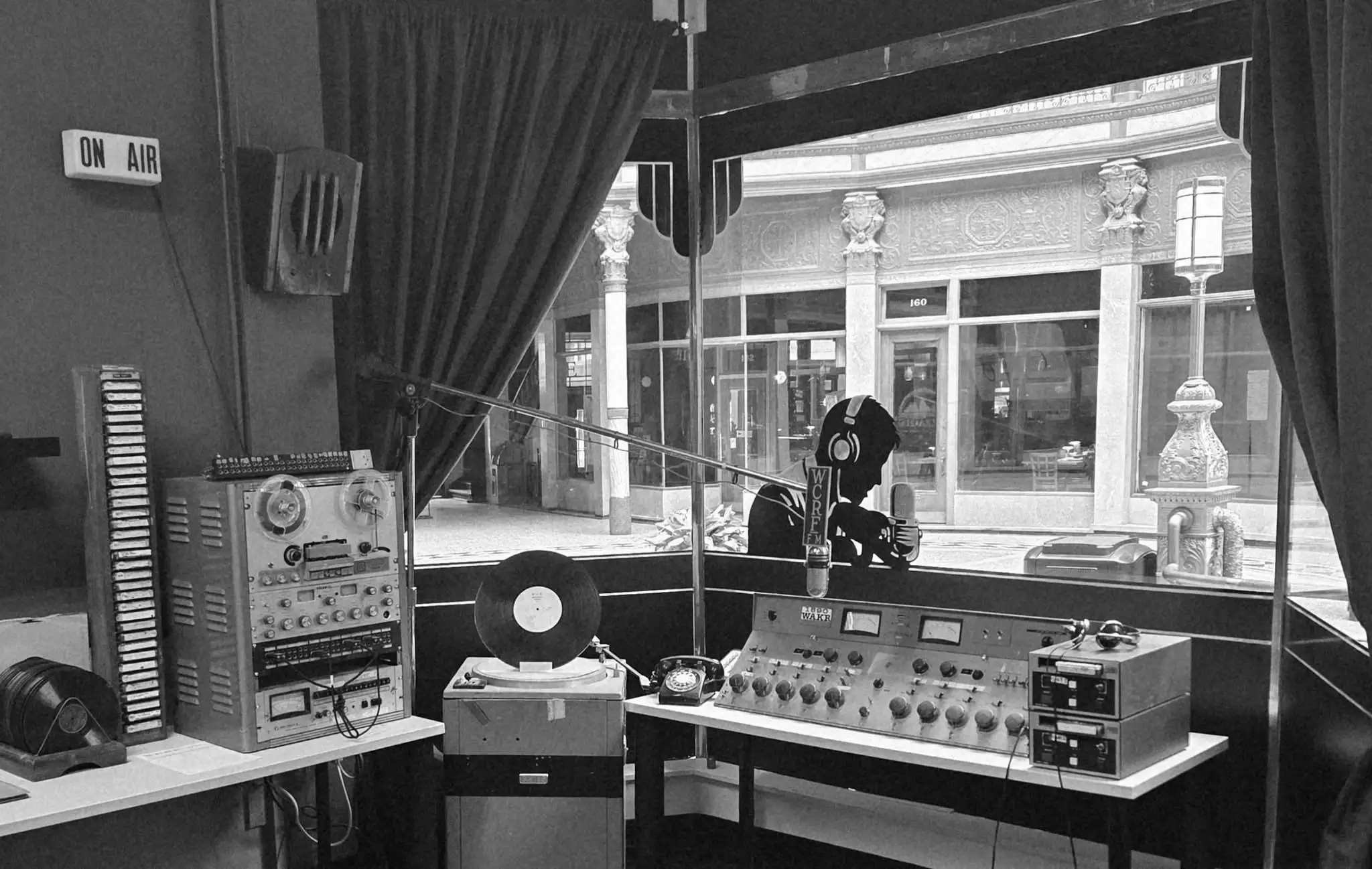 a man in headphones sitting in front of a window